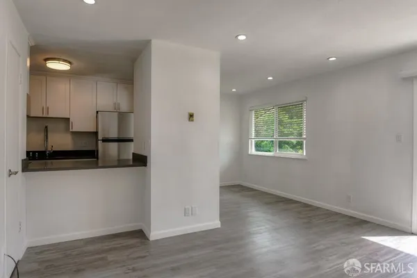 an empty room with wooden floor and a window