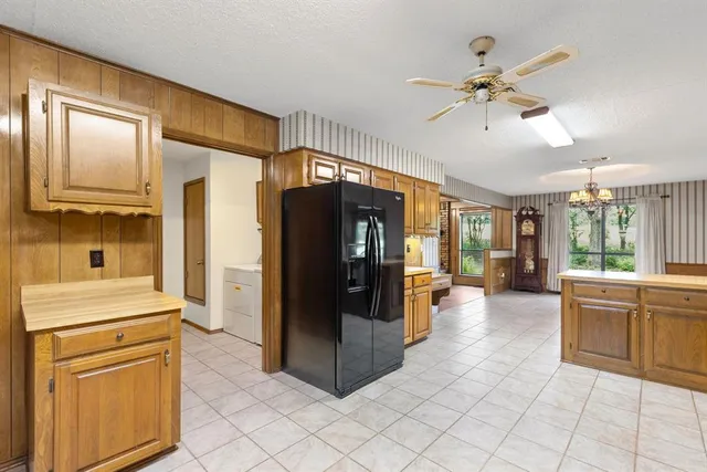 a kitchen with kitchen island granite countertop a sink stove and refrigerator