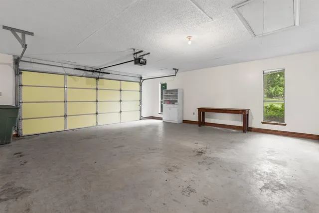 an aerial view of residential houses with outdoor space and trees