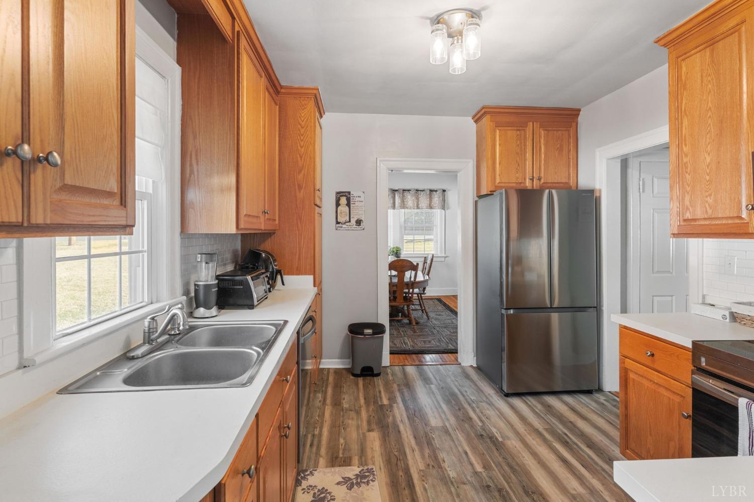 133 Ridge Drive Amherst, VA 24521 - Photo 21 of 61 a kitchen with wooden cabinets a sink a counter top space stainless steel appliances and a window