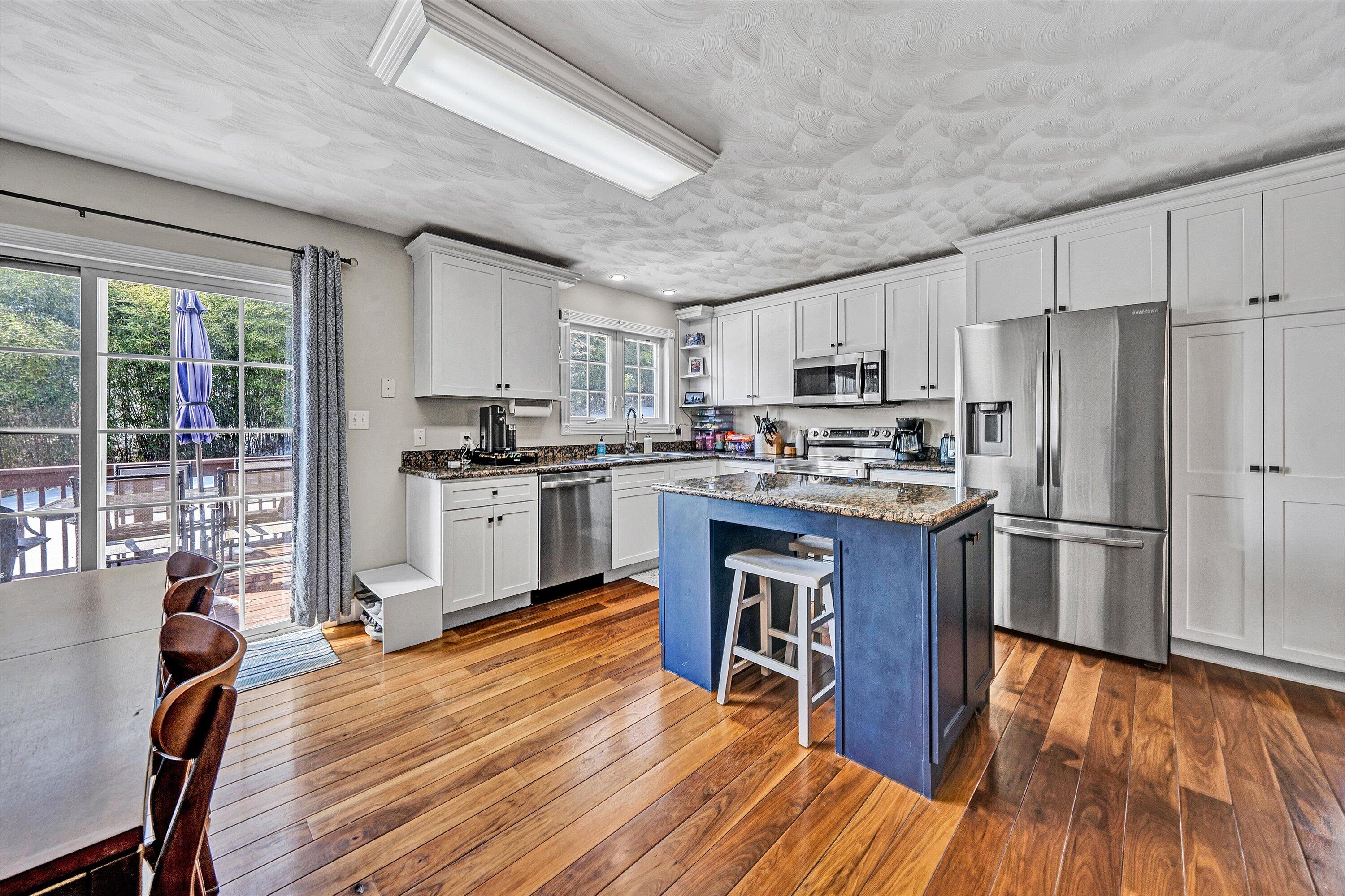 409 Wills Road Lexington, VA 24450 - Photo 11 of 42 a kitchen with granite countertop wooden floors stainless steel appliances and a window