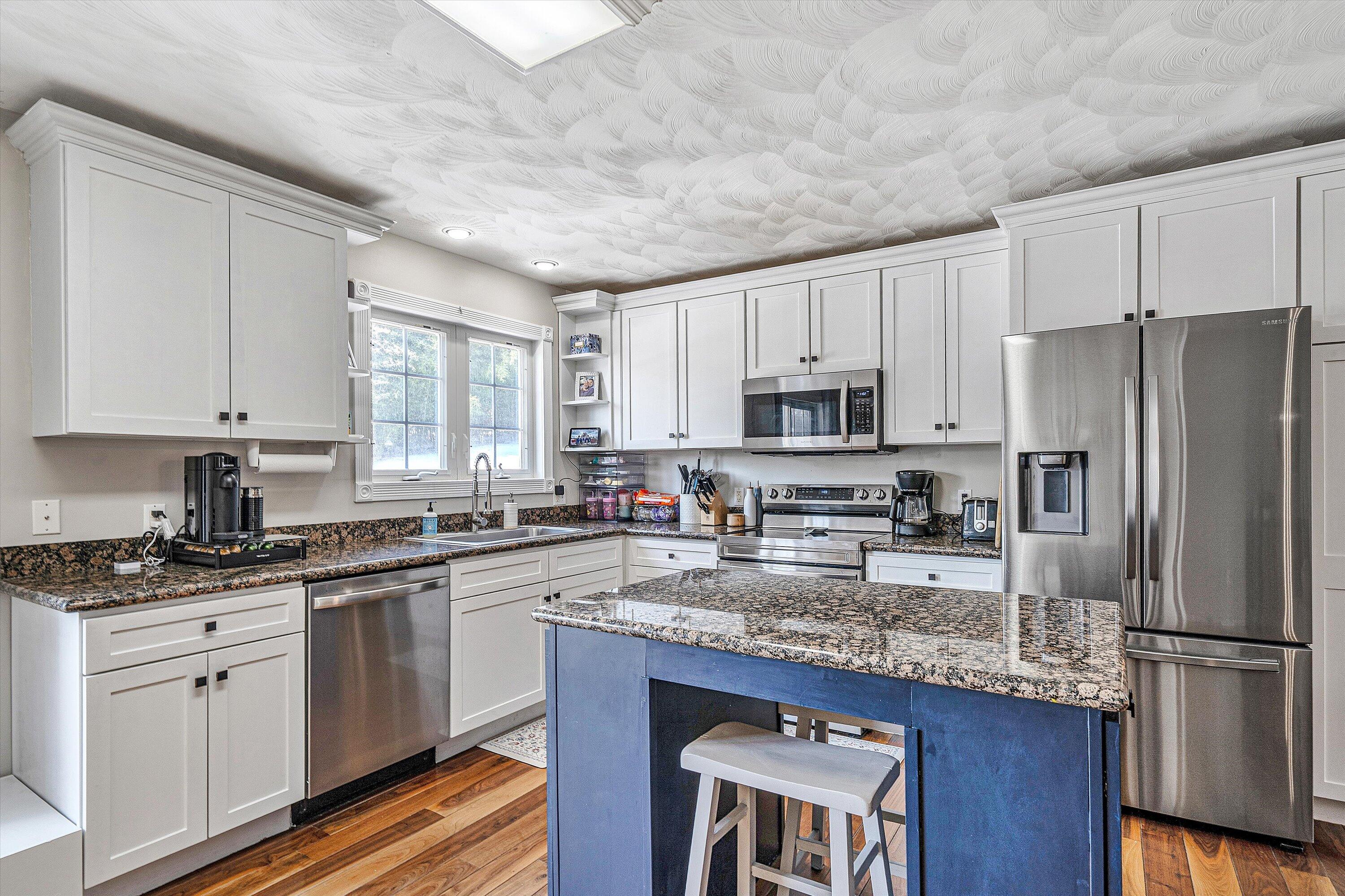 409 Wills Road Lexington, VA 24450 - Photo 13 of 42 a kitchen with stainless steel appliances granite countertop a stove a sink dishwasher a refrigerator and white cabinets with wooden floor
