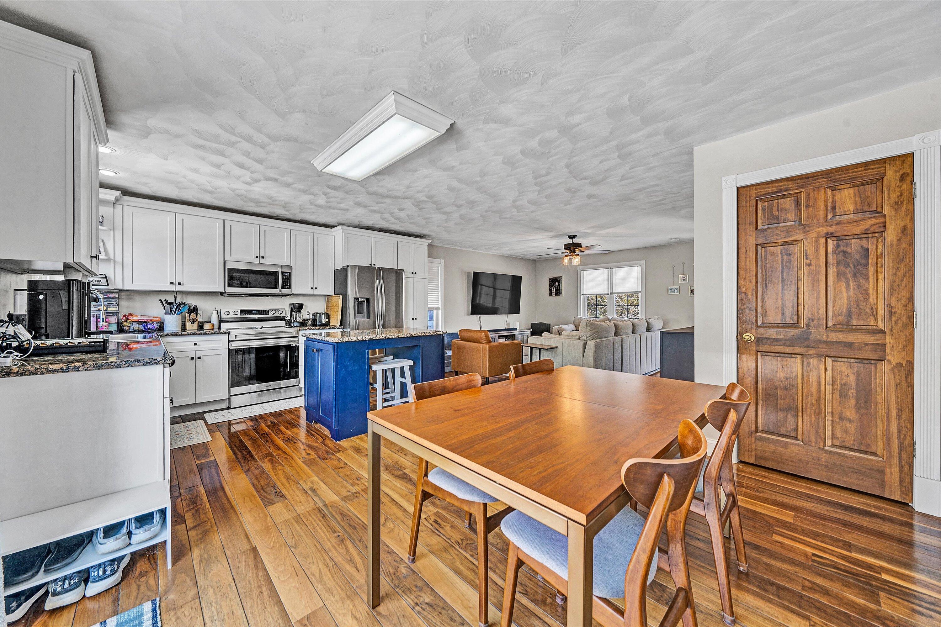 409 Wills Road Lexington, VA 24450 - Photo 16 of 42 a kitchen with stainless steel appliances granite countertop a stove top oven a sink dishwasher a dining table and chairs with wooden floor