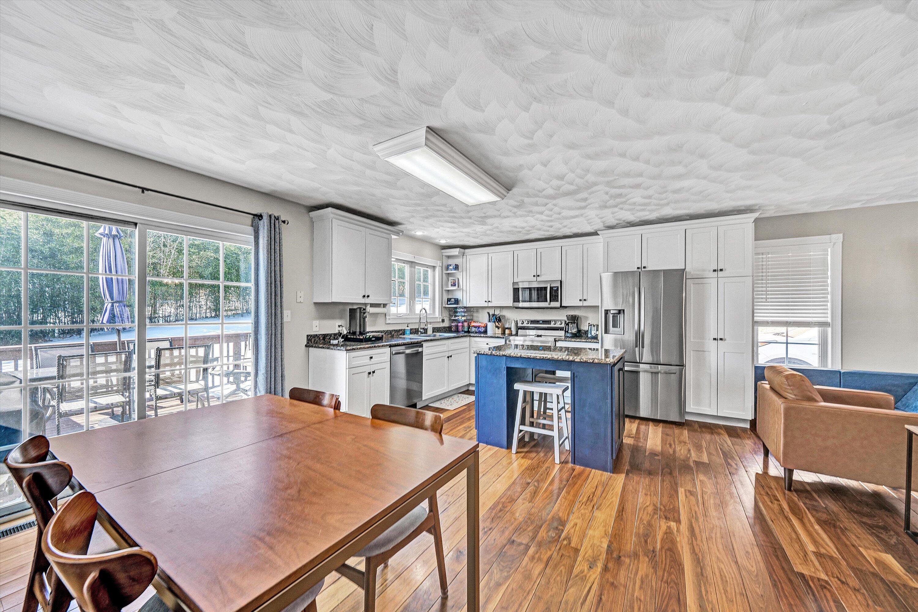 409 Wills Road Lexington, VA 24450 - Photo 17 of 42 a open kitchen with stainless steel appliances granite countertop a refrigerator a stove top oven a sink dishwasher and white cabinets with wooden floor
