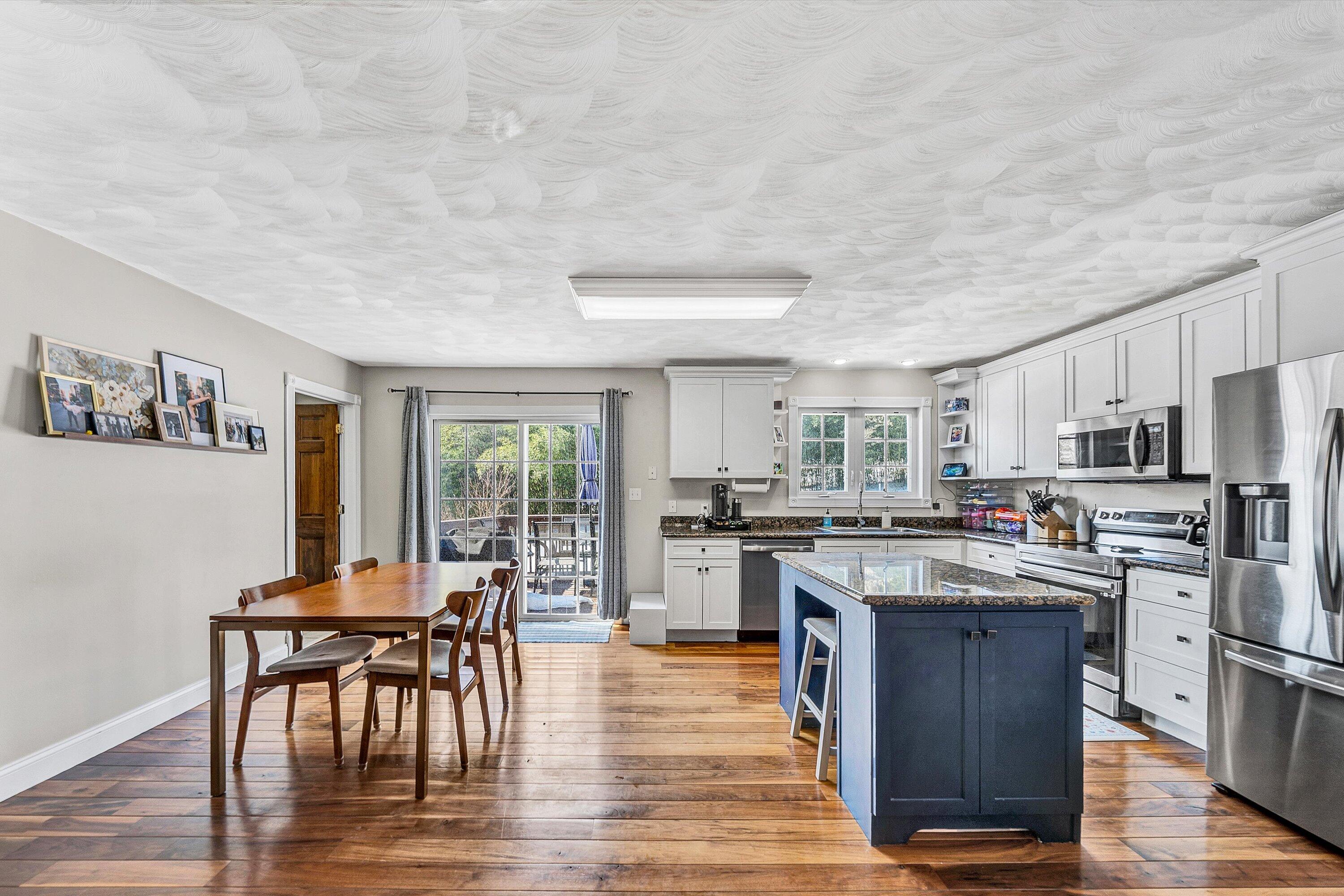 409 Wills Road Lexington, VA 24450 - Photo 9 of 42 a kitchen with stainless steel appliances granite countertop a stove top oven a sink dishwasher a dining table and chairs with wooden floor