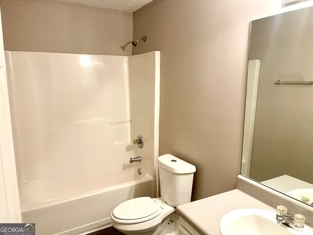 a white toilet sitting next to a bathroom sink and a shower