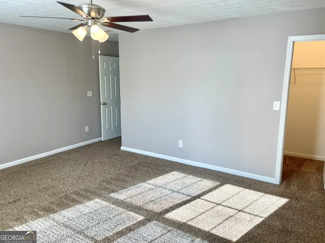 an empty room with a fan and a window