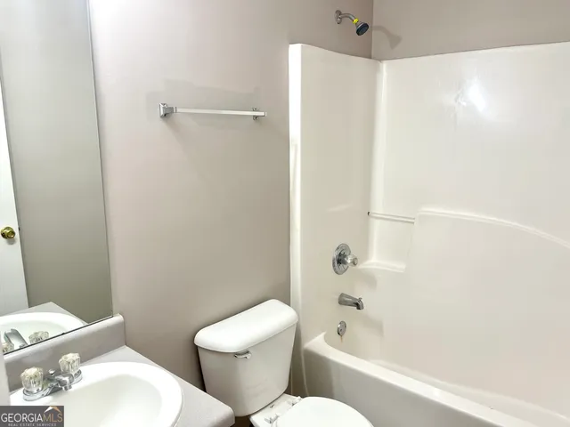 a white toilet sitting next to a bath tub