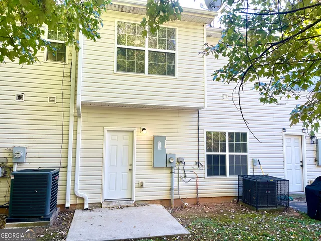 a view of house with backyard and sitting area