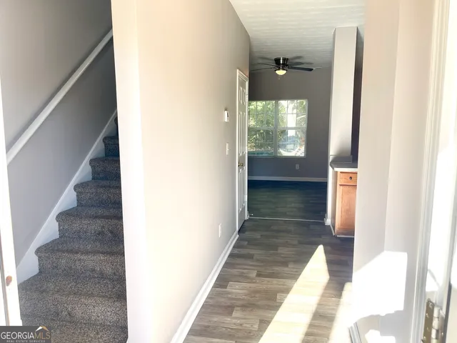 a view of a hallway with wooden floor and staircase