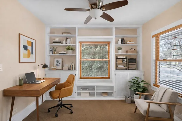 a workspace with a desk chair and painted walls with a bookshelf