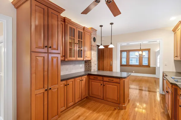 a kitchen with stainless steel appliances granite countertop a refrigerator a sink and wooden cabinets