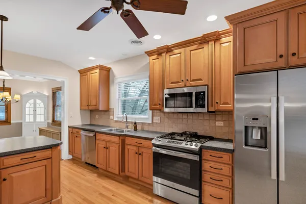 a kitchen with stainless steel appliances granite countertop a stove a sink and a refrigerator