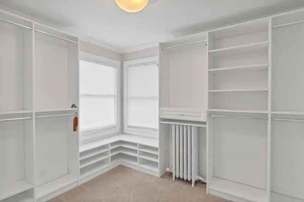 a bedroom with a bed a dresser and chair