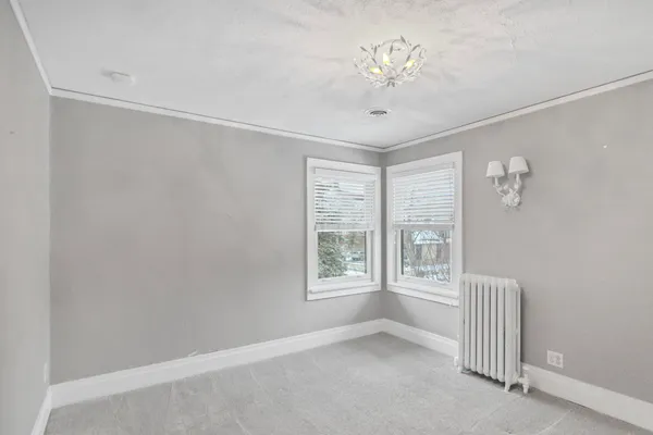 a view of an empty room with a chandelier fan