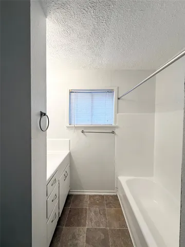 a bathroom with a tub sink and mirror