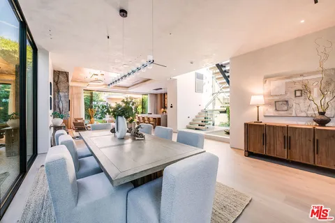 a view of a dining room and livingroom with furniture window and wooden floor