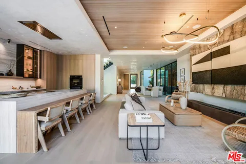 a living room with lots of wooden furniture and a large window