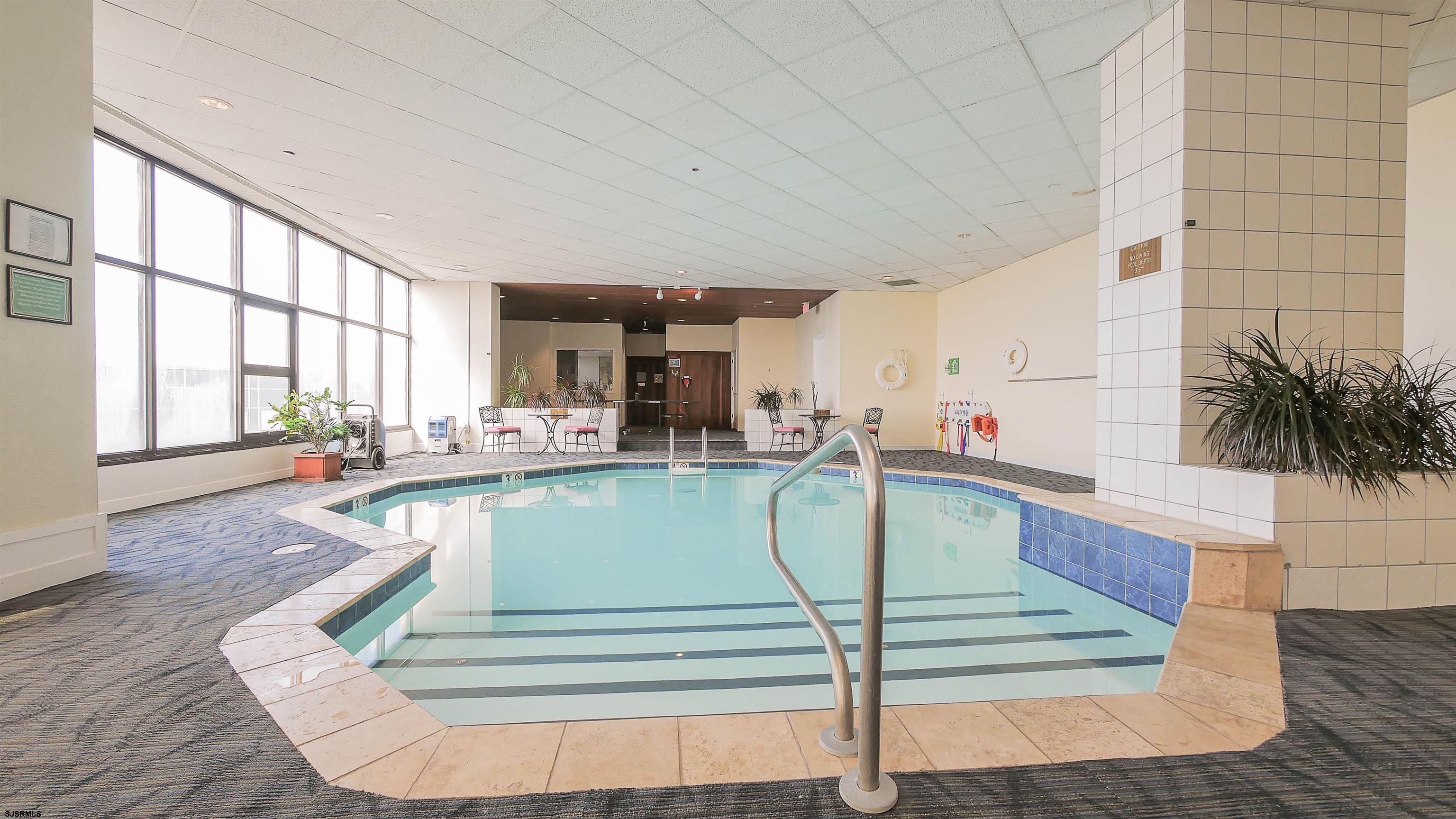 3851 Boardwalk, Unit 1405 Atlantic City, NJ 08401 - Photo 24 of 36 a living room with a floor to ceiling window and potted plants