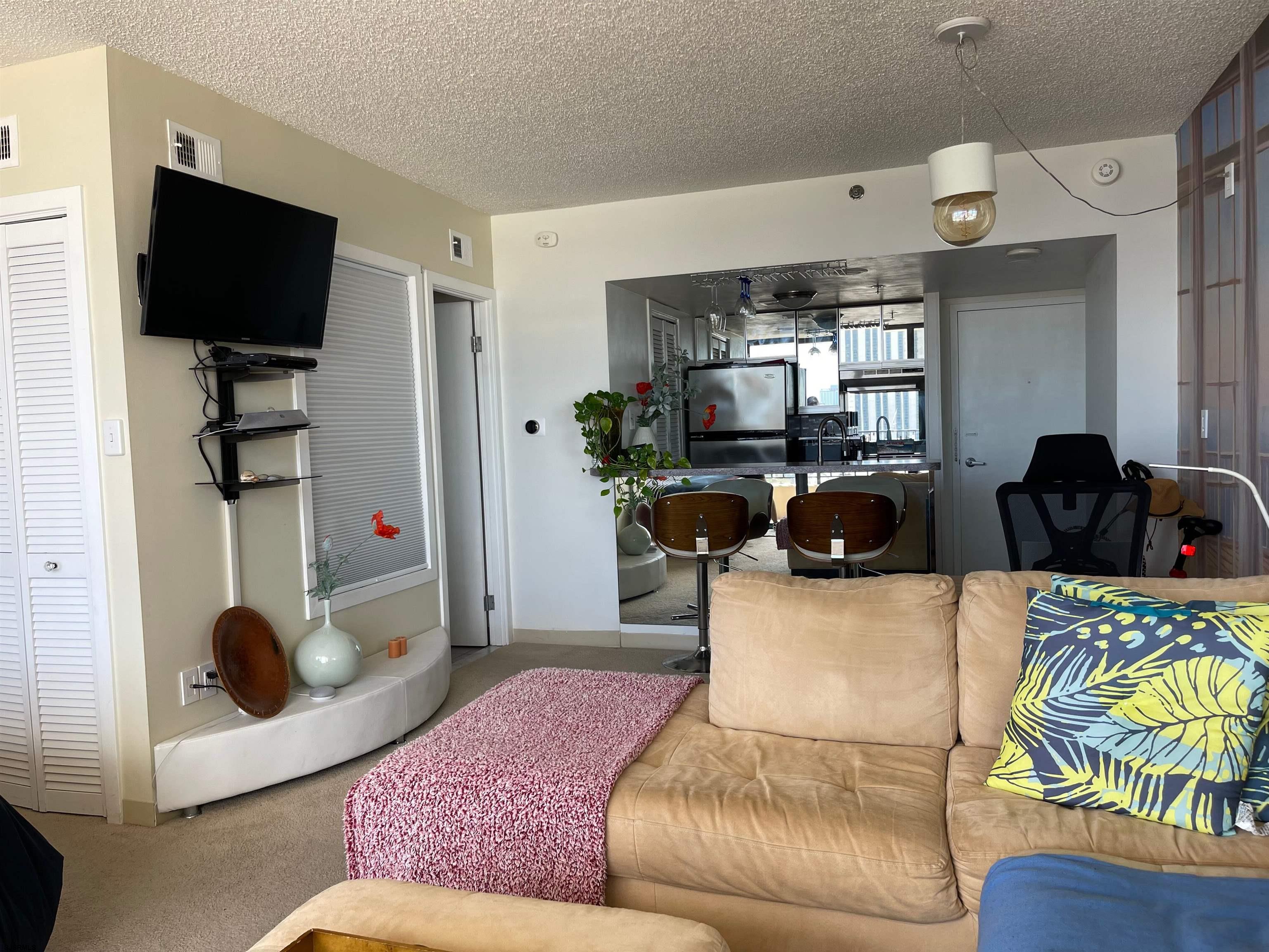 3851 Boardwalk, Unit 1405 Atlantic City, NJ 08401 - Photo 9 of 36 a living room with furniture and a flat screen tv