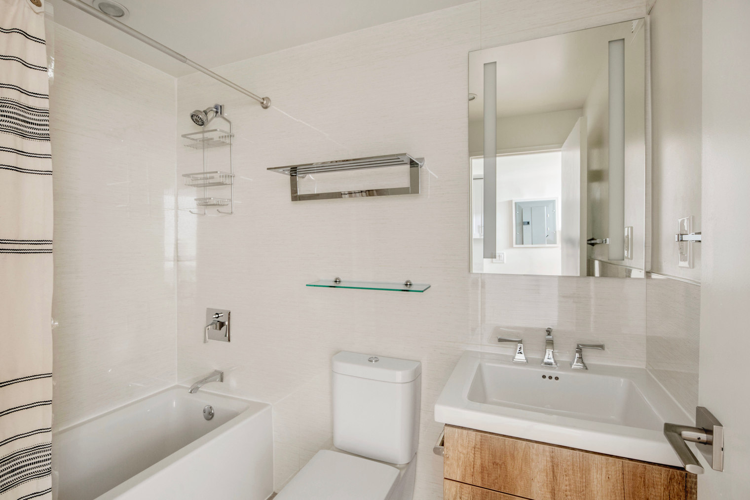 a bathroom with a bathtub shower sink vanity and toilet