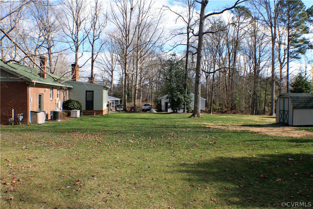 9931 Trebeck Road Chesterfield, VA 23236 - Photo 31 of 43 a view of a white house with a big yard and large trees