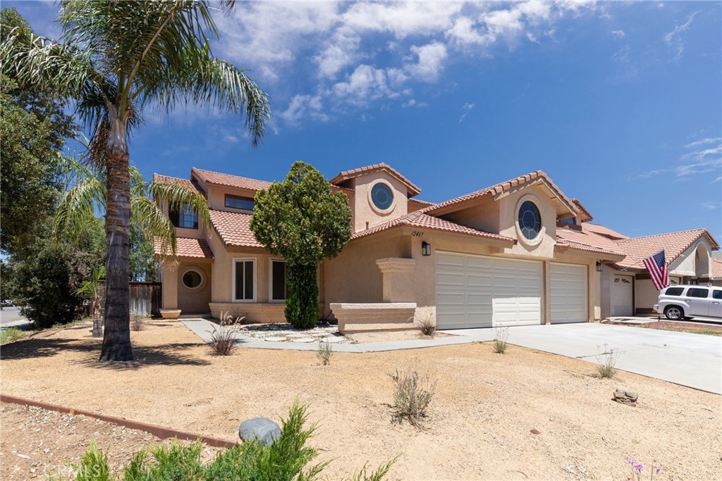 a front view of a house with a yard and palm trees
