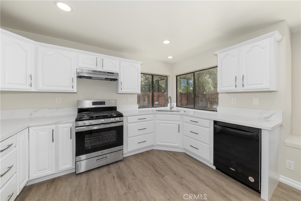 32465 Cape Cod Drive Lake Elsinore, CA 92530 - Photo 11 of 29 a kitchen with granite countertop white cabinets and appliances