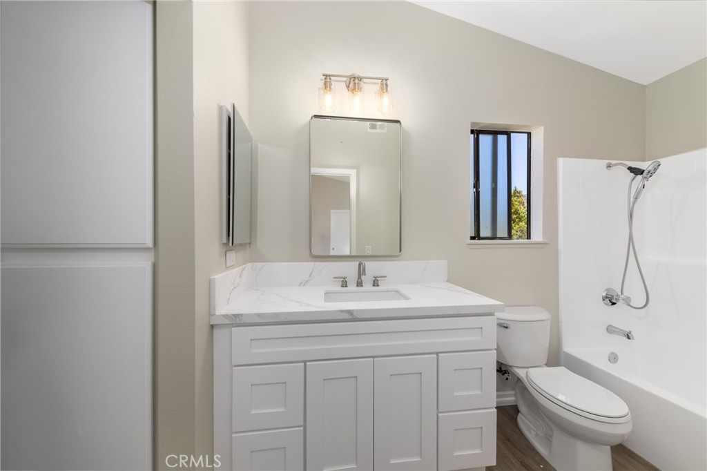 32465 Cape Cod Drive Lake Elsinore, CA 92530 - Photo 19 of 29 a bathroom with a toilet sink vanity and mirror