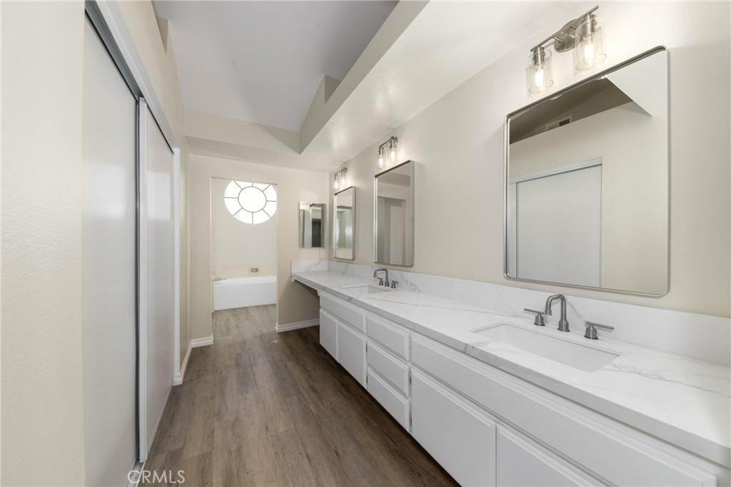 32465 Cape Cod Drive Lake Elsinore, CA 92530 - Photo 23 of 29 a spacious bathroom with a double vanity sink and mirror