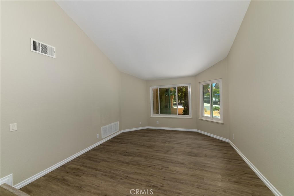 32465 Cape Cod Drive Lake Elsinore, CA 92530 - Photo 5 of 29 a view of an empty room with wooden floor and a window