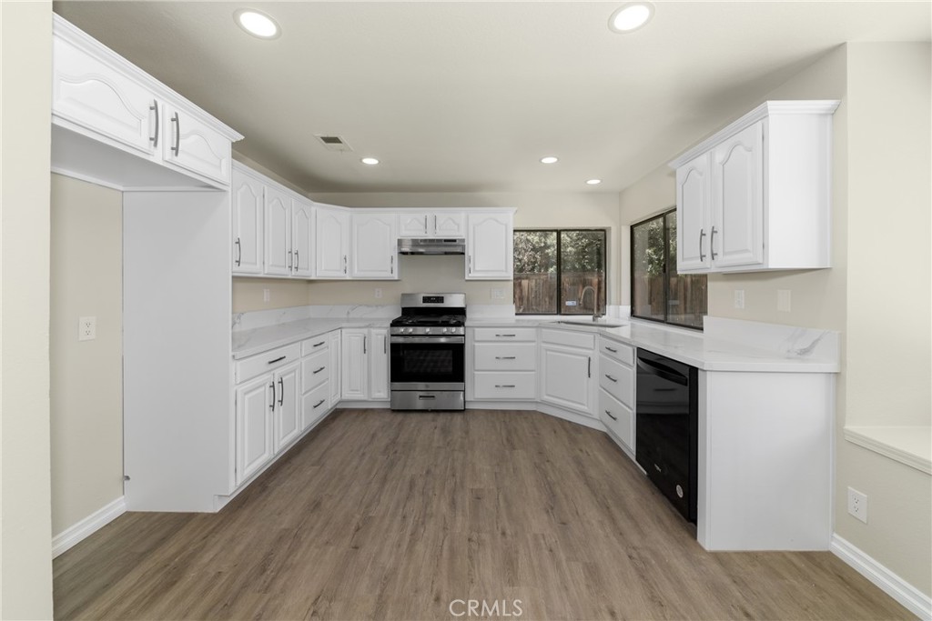 32465 Cape Cod Drive Lake Elsinore, CA 92530 - Photo 10 of 29 a kitchen with cabinets wooden floor and stainless steel appliances