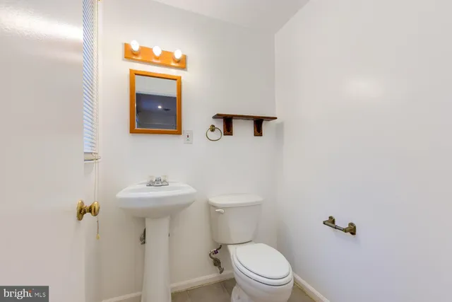 a bathroom with a sink mirror and toilet