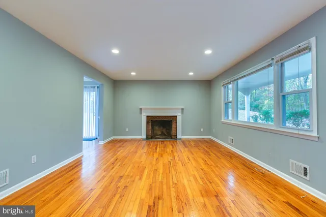 a view of empty room with wooden floor and fireplace
