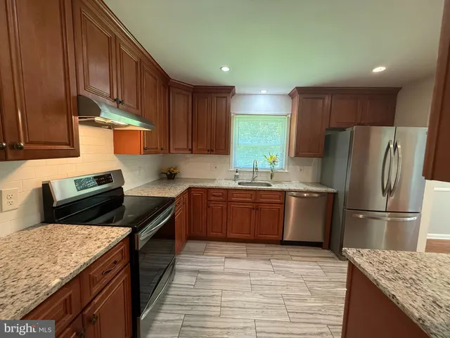 a kitchen with stainless steel appliances granite countertop a stove a refrigerator and a sink