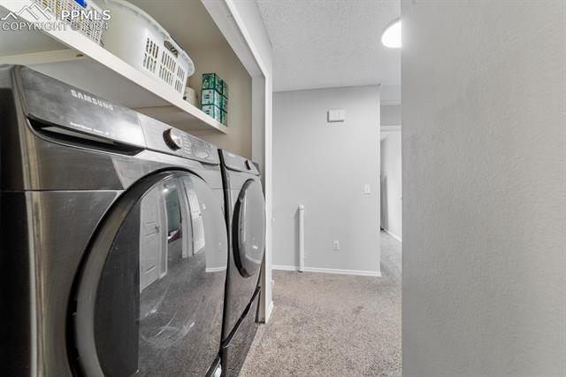 6525 Bismark Road Colorado Springs, CO 80922 - Photo 27 of 38 Laundry room with separate washer and dryer and a textured ceiling