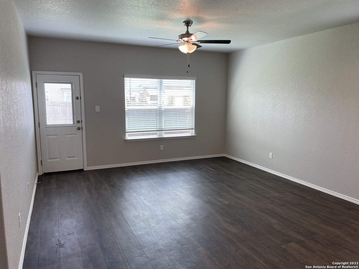 12904 Candace Way St. Hedwig, TX 78152 - Photo 5 of 15 an empty room with wooden floor chandelier fan and windows