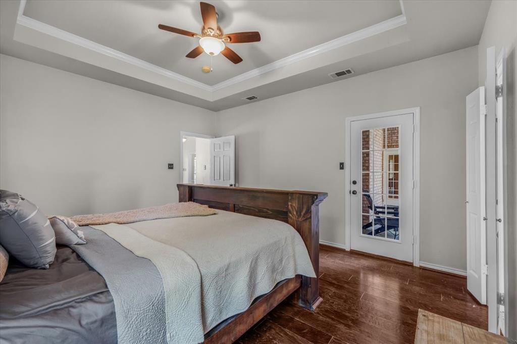 910 Crystal Cove Oak Point, TX 75068 - Photo 21 of 40 a bedroom with a large bed and a chandelier