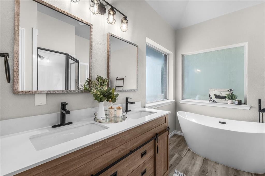 910 Crystal Cove Oak Point, TX 75068 - Photo 22 of 40 a bathroom with a bathtub a sink and mirror