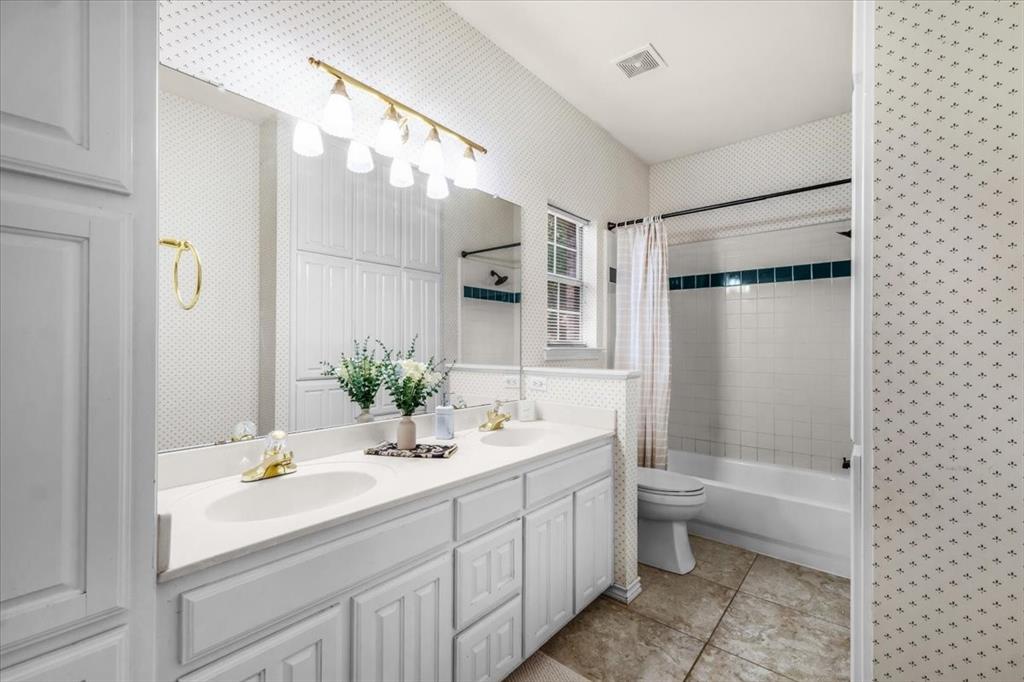 910 Crystal Cove Oak Point, TX 75068 - Photo 29 of 40 a bathroom with a double vanity sink toilet mirror and bathtub