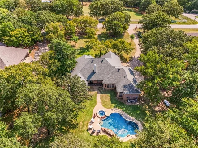 an aerial view of a house with swimming pool and garden view