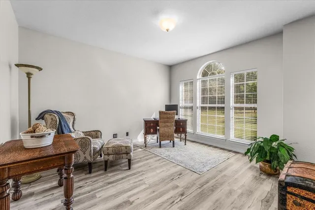 a living room with furniture fireplace and a large window