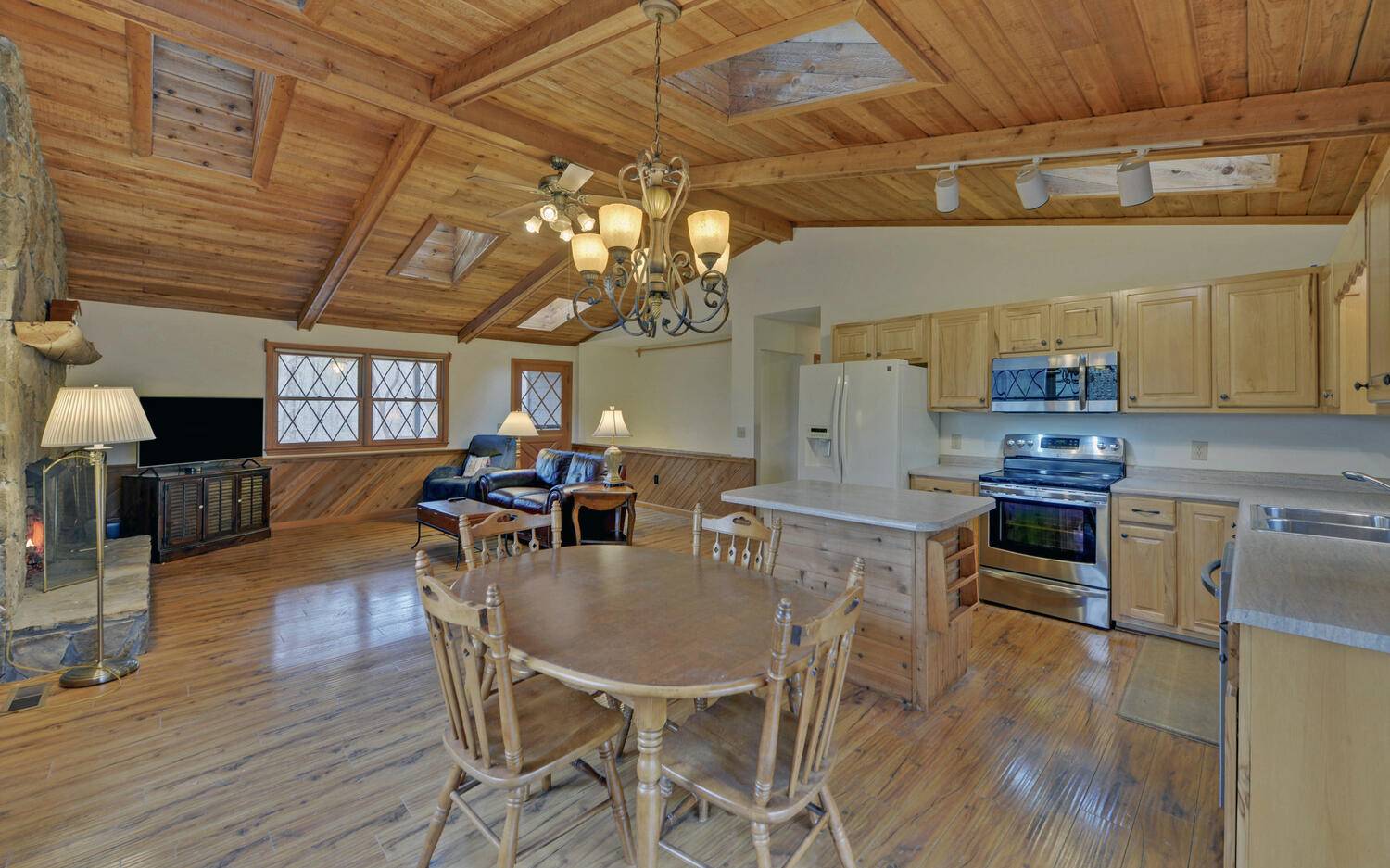 2139 Lake Louisa Road Hiawassee, GA 30546 - Photo 4 of 48 a kitchen with stainless steel appliances granite countertop a stove a refrigerator a dining table and chairs with wooden floor
