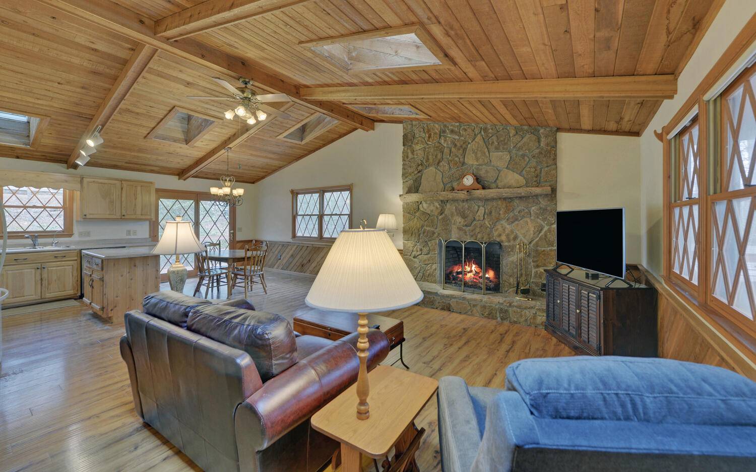 2139 Lake Louisa Road Hiawassee, GA 30546 - Photo 7 of 48 a living room with furniture a flat screen tv and a fireplace