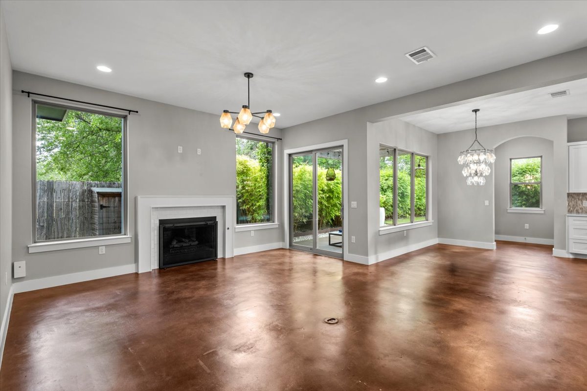 913 Stobaugh Street, Unit B Austin, TX 78757 - Photo 11 of 40 Natural light floods this living and dining area, highlighting the rich sheen of the floors.