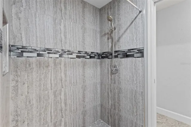 a bathroom with a granite countertop sink a large mirror and a shower