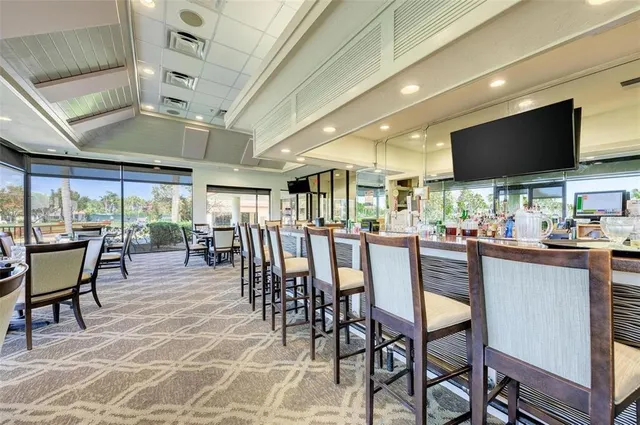 a kitchen with stainless steel appliances granite countertop a table chairs sink refrigerator and microwave