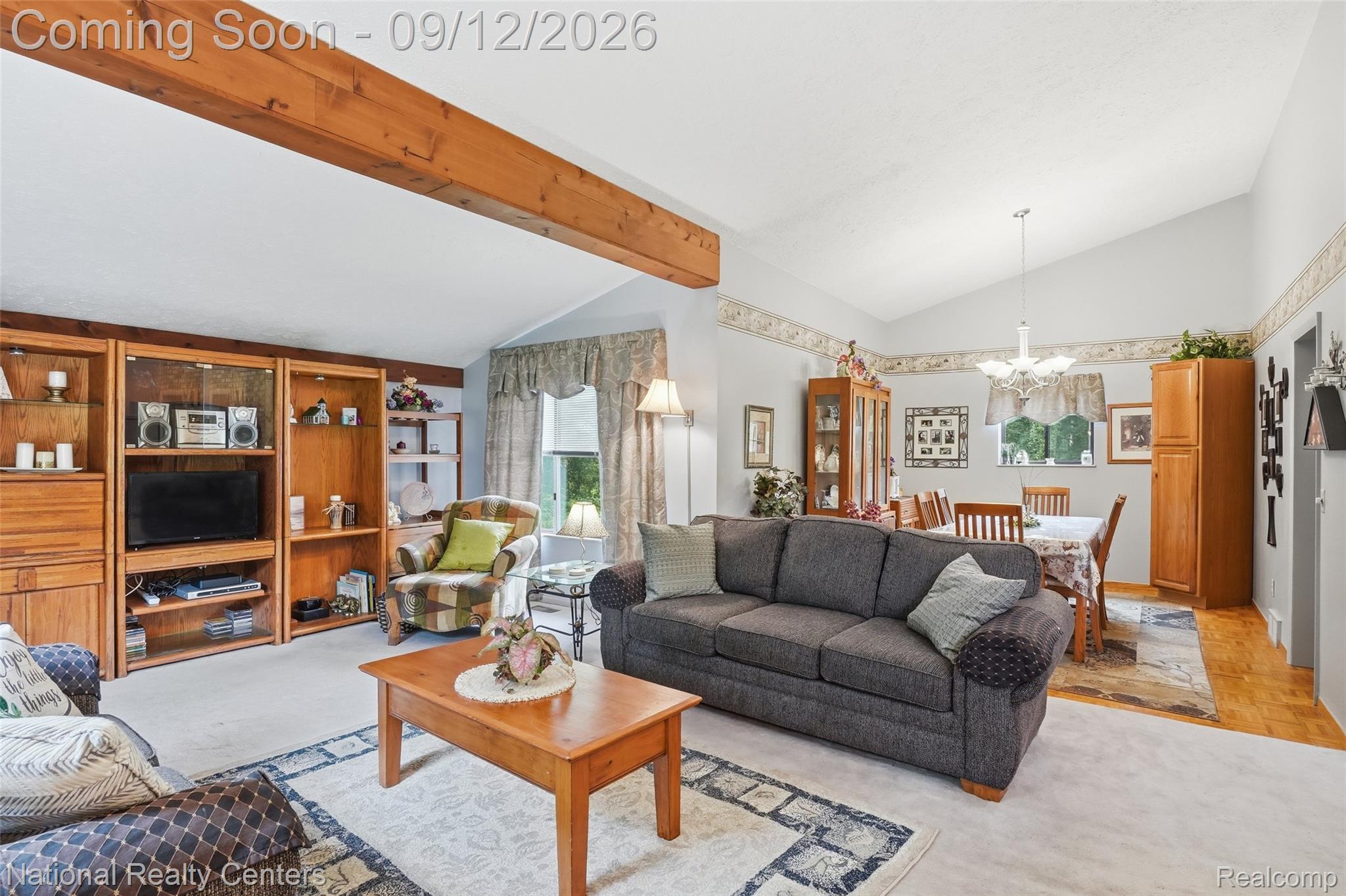 2631 Garden Road Milford, MI 48381 - Photo 18 of 40 Vaulted ceiling, exposed wood beam, built-in wooden shelving, and a dining area with a chandelier