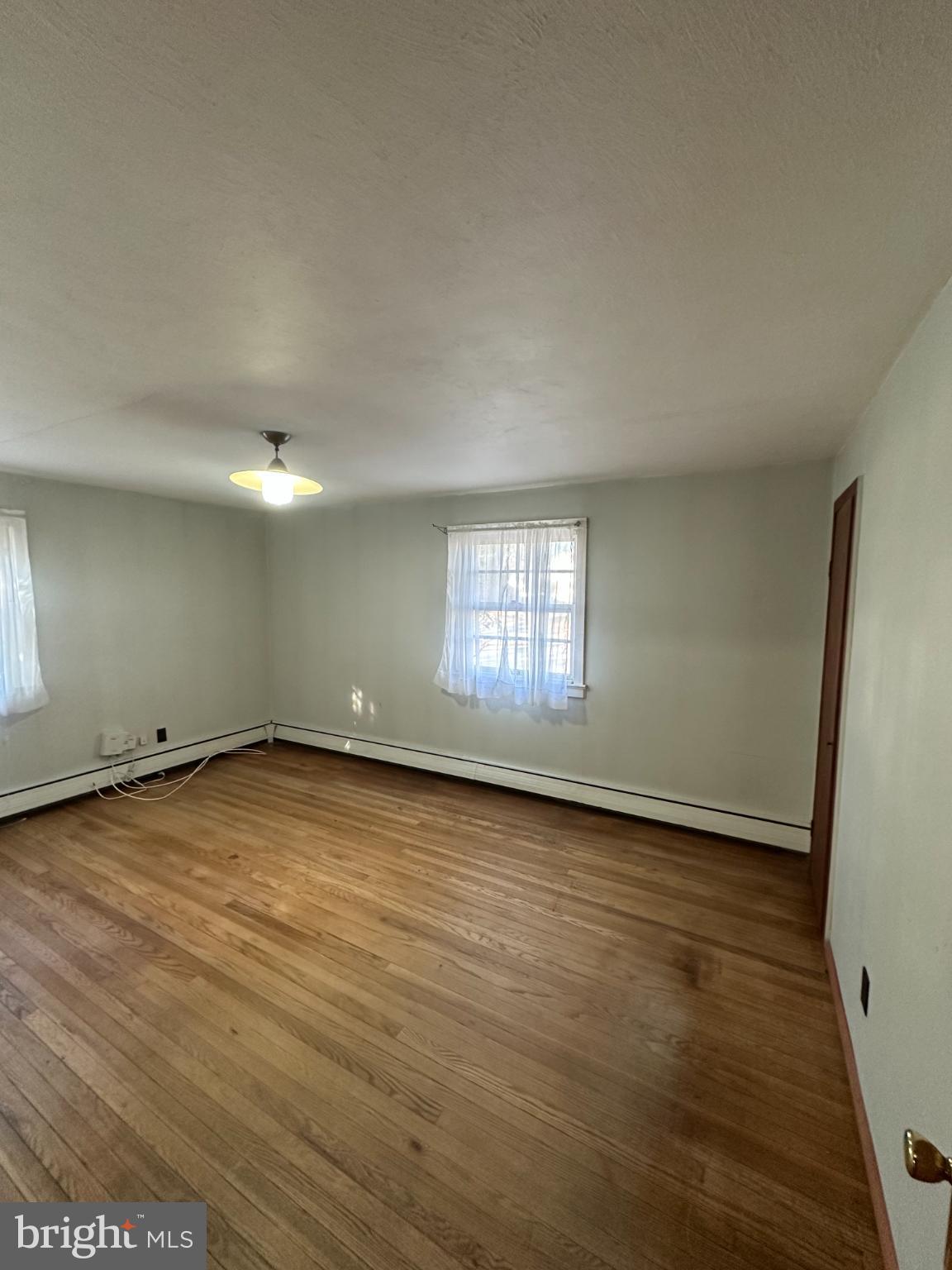809 Somerdale Road Voorhees, NJ 08043 - Photo 9 of 20 an empty room with wooden floor and windows
