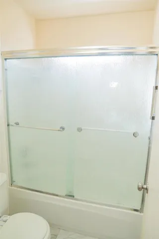 a bathroom with a toilet and a shower